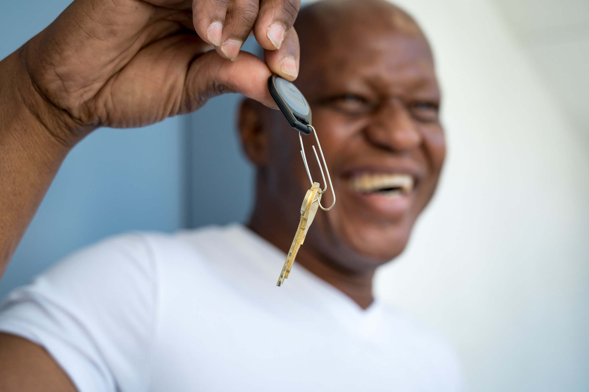 Man smiling holding keys in hand