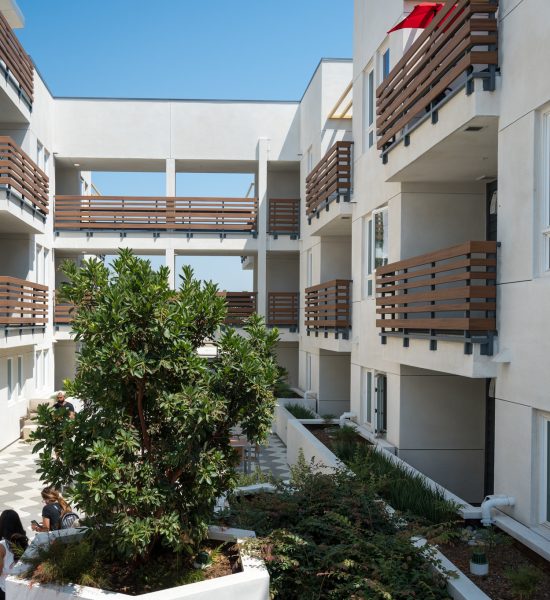 Courtyard of a modern apartment complex with balconies and plants.