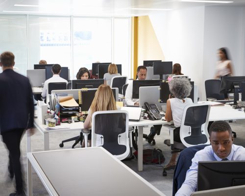 Man walking through a busy open plan office